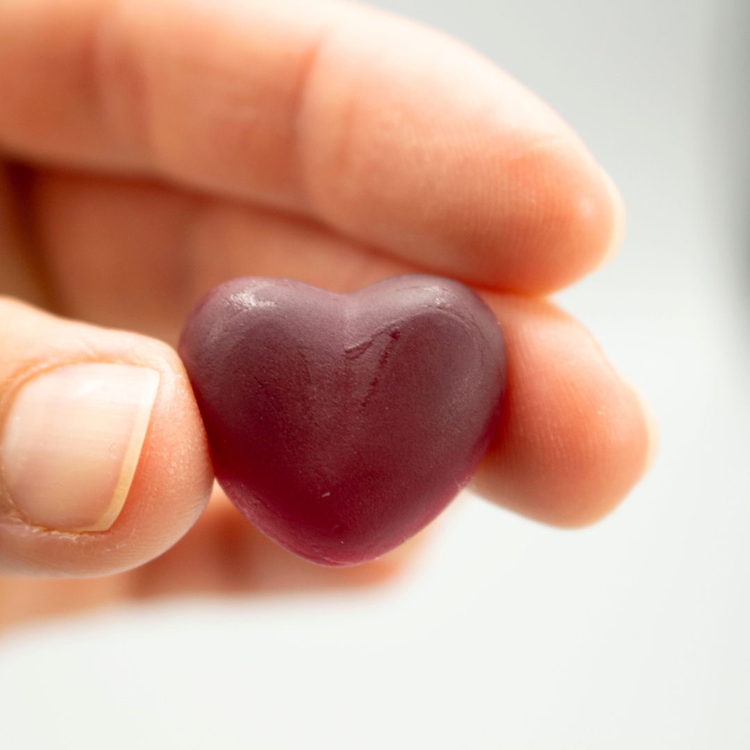 Ein NUI NONI Gummiherz in der Hand